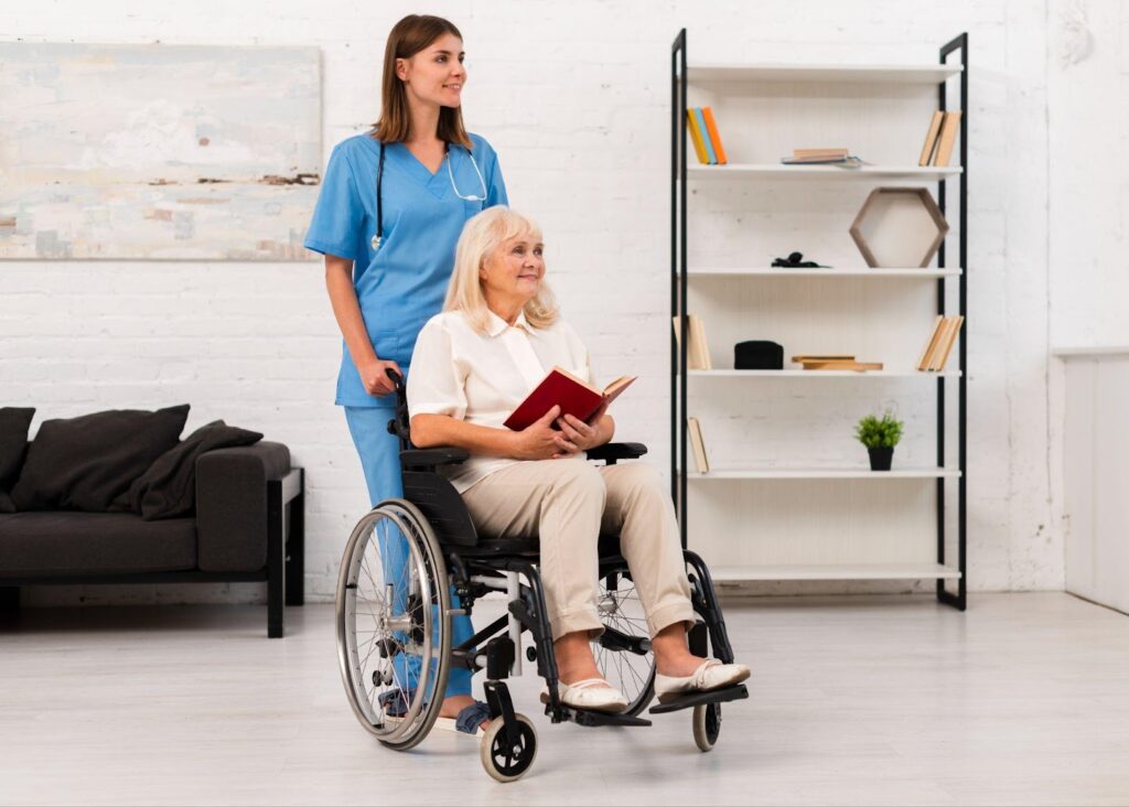 A healthcare assistant moving an individual in a wheelchair.